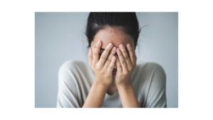 Image of a woman covering her face. Showing someone who could benefit from PTSD treatment & trauma therapy in Colorado Springs, CO. With guidance of a trauma therapist you can beat your symptoms.