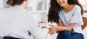 Image of a woman speaking with a depression therapist in Colorado Springs. Representing CBT or DBT which can be used as a treatment of symptoms in depression therapy. 