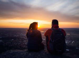 Image of a couple resting after hiking together. Which shows a date night that a Colorado Springs couples therapist might suggest. You can get even more support with couples therapy in Colorado Springs. We also offer online couples counseling in Colorado.