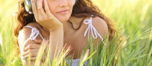 Image of a woman laying in the grass with a slight smile. Representing someone who has healed from traumatic grief in online therapy in Colorado Springs, CO.