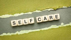 A close up of letters with the word self-care. Learn how anxiety therapy in Colorado Springs, CO can help by contacting an online therapist in Colordao. Search “anxiety symptoms Colorado Springs, CO” today to learn more. 
