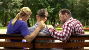 A teen talks with their parents on a park bench. Learn how a therapist for teenagers in Colorado Springs, CO can offer support with teen counseling in Colorado Springs, CO. Or, search for counseling for teens near me. 