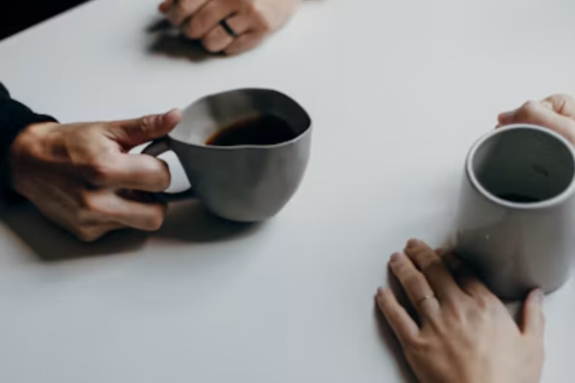 Couple talking across a table over coffee, working through a conversation before marriage counseling in Colorado Springs